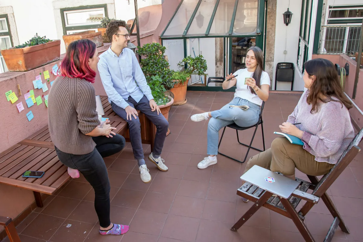 Small group of people having a relaxed and informal group session outdoors on a sunny terrace